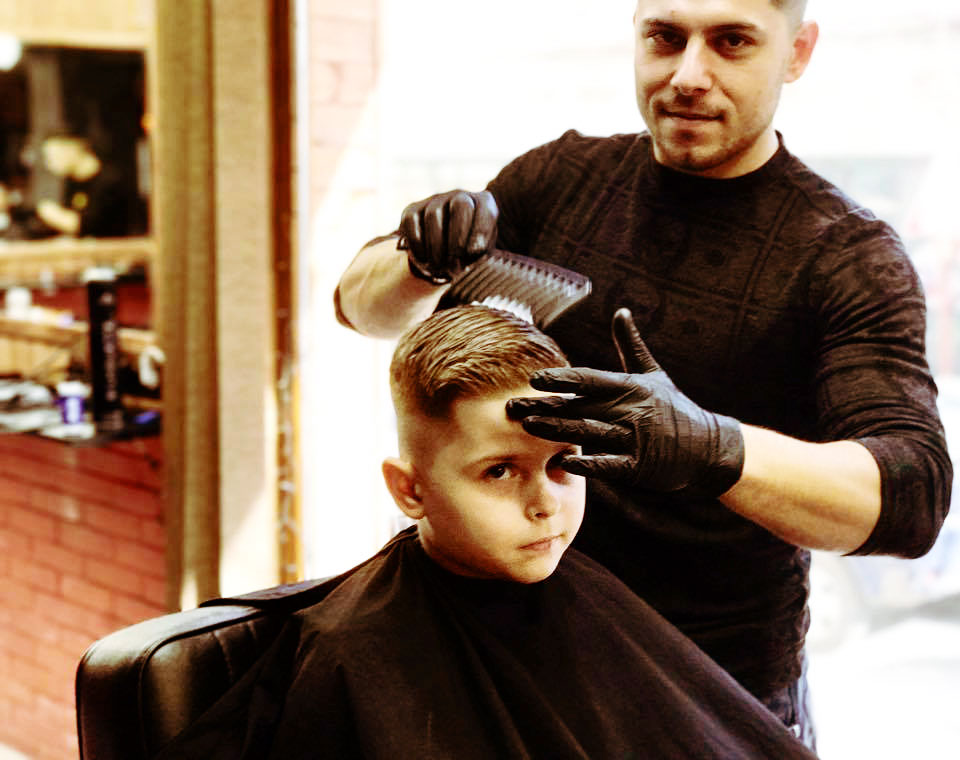 A child is getting a modern haircut at Bradao Barbershop in Varna Bulgaria